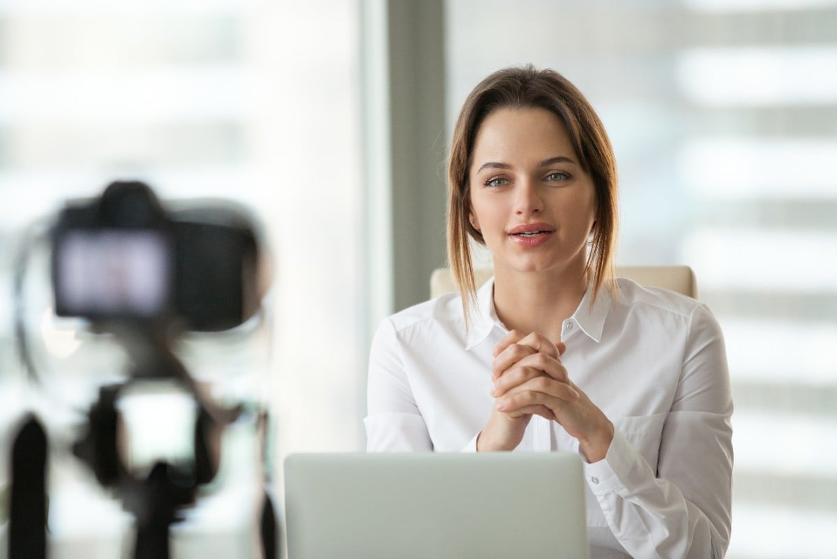 Female executive live-streaming video to colleagues  
