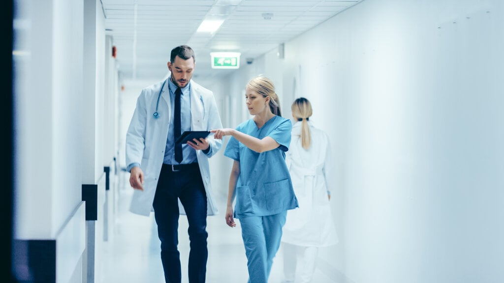 Doctor and nurse using tablet and team collaboration software